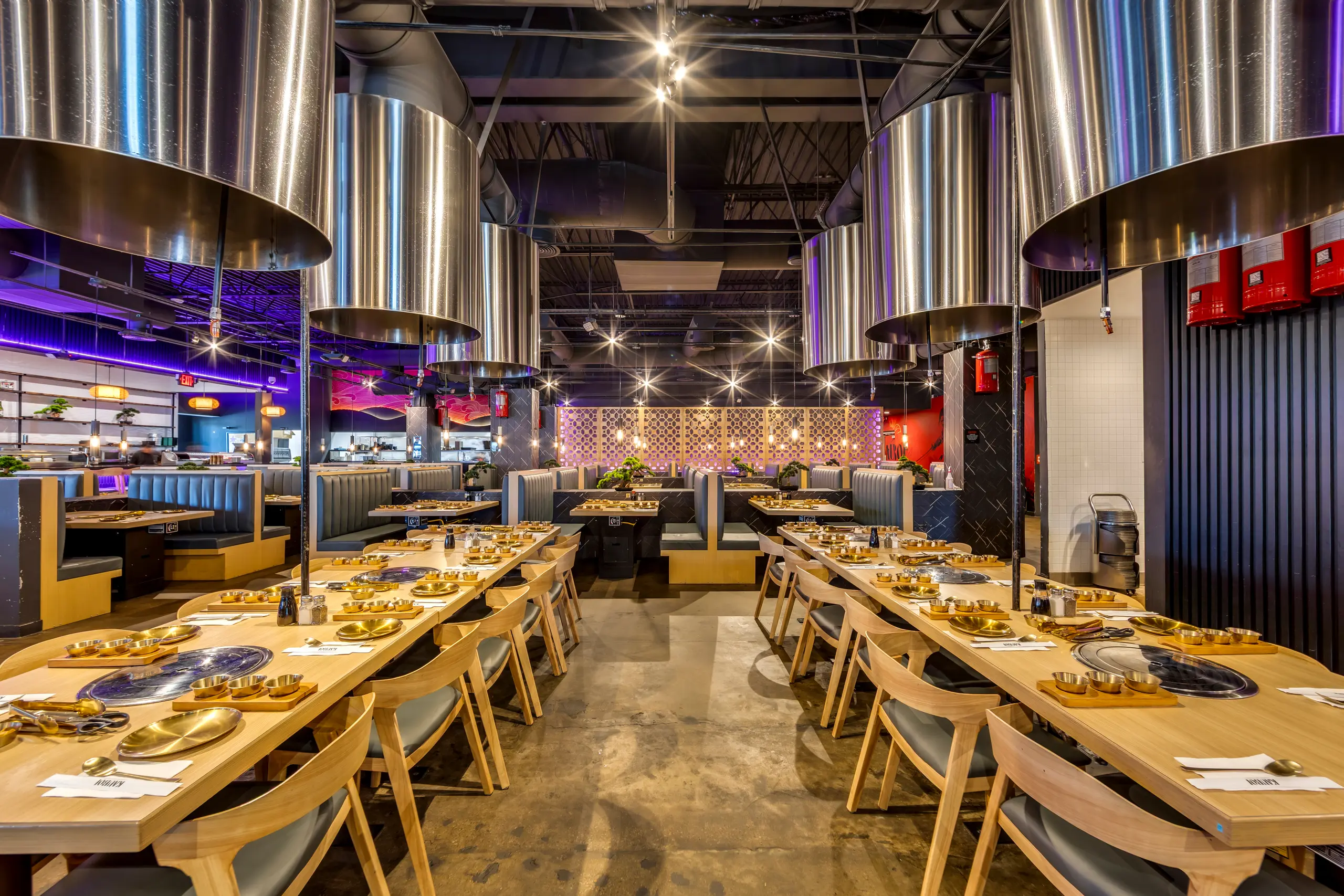 Kauboi BBQ main dining room — communal Korean BBQ tables and overhead exhaust hoods